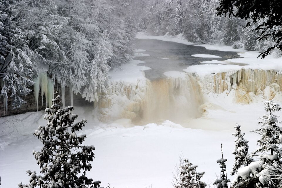Amber frozen cascades and cedar snow forest at Upper Tahquamenon Falls