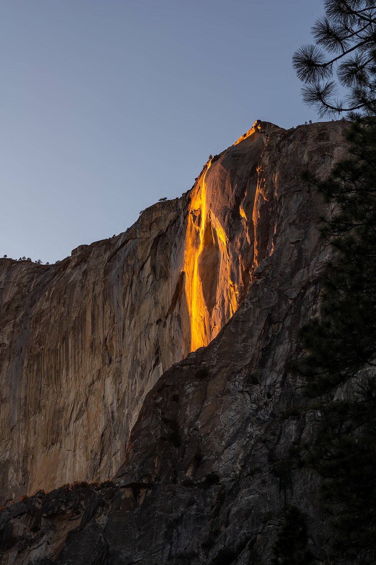 Horsetail Fall glowing fiery orange against the granite wall of El Capitan at sunset in Yosemite National Park